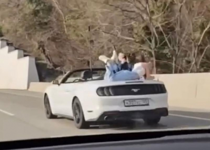 Фотосессию на багажнике движущегося кабриолета устроила девушка в Сочи